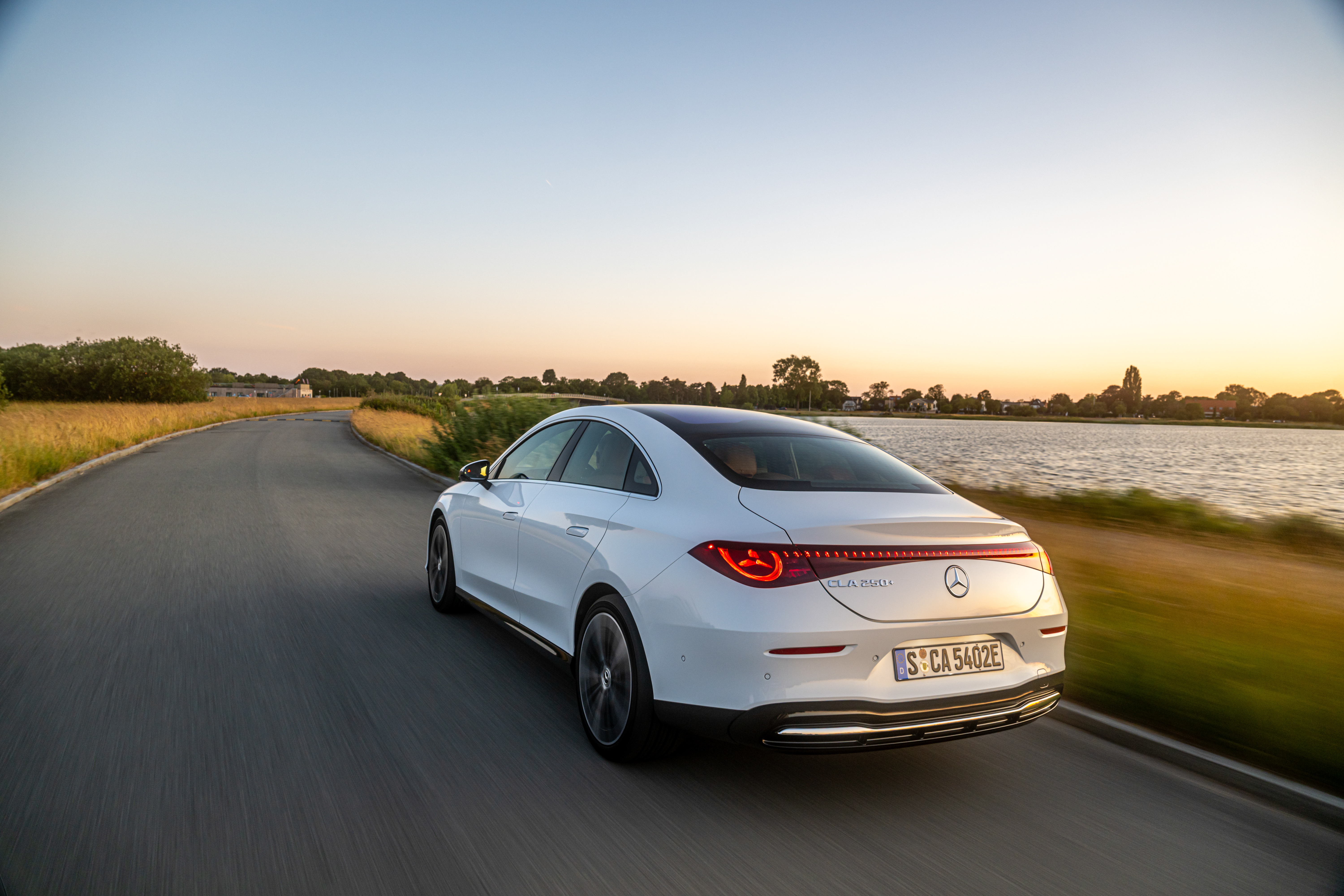 Noul Mercedes-Benz CLA 250+ electric alb &mdash; spate &icirc;n mișcare la apus de soare